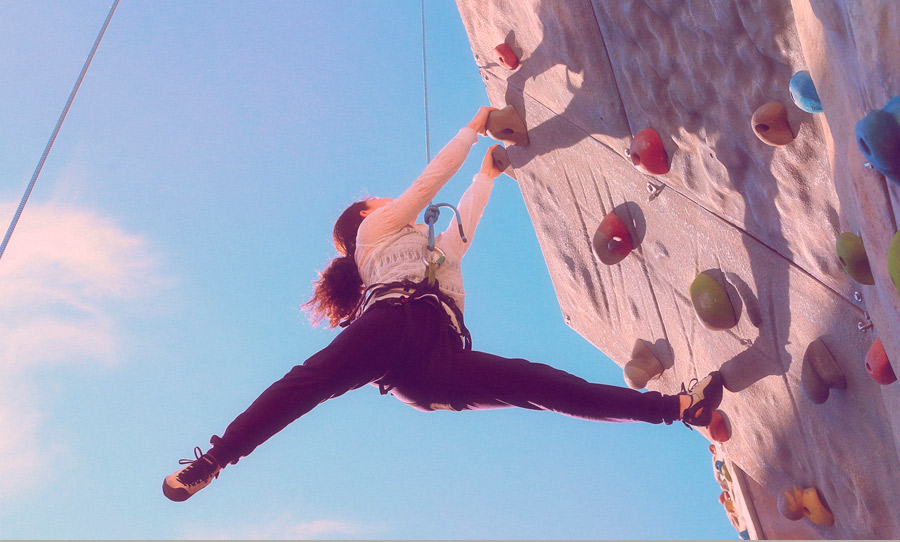 Chica escalando en el rocódromo exterior del SAF